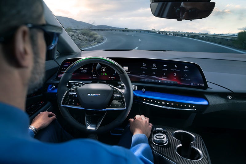 Front View of the 2026 OPTIQ-V Driving Through the Dusk Utilizing its Headlights | Brogan Cadillac of Totowa in Totowa NJ